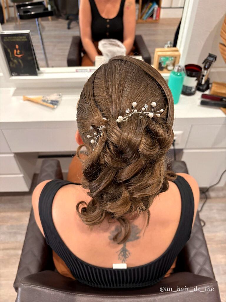 Curled updo with pearl hair pin, back view