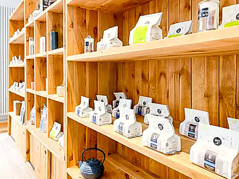 Wooden shelves of tea and a cast-iron teapot in the salon's tea shop